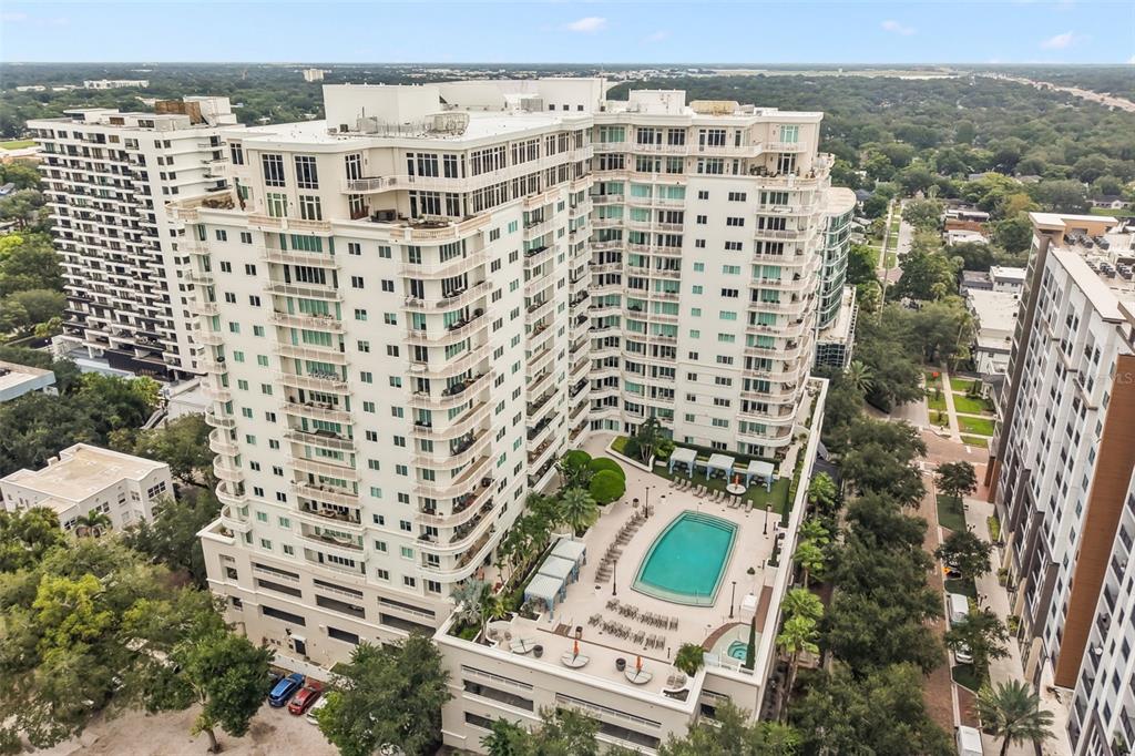 An aerial view of a multi-story apartment building with a swimming pool and patio area — 100 S EOLA DRIVE UNIT 119, ORLANDO, FL