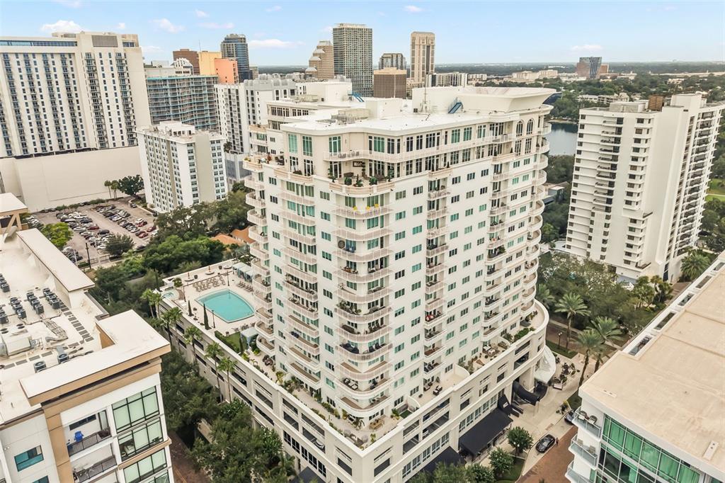 An aerial view of a high-rise condominium building featuring balconies and an outdoor swimming pool — 100 S EOLA DRIVE UNIT 119, ORLANDO, FL