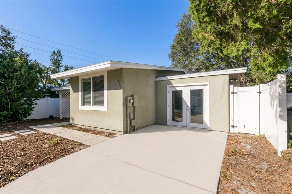 A single-story house exterior with a concrete driveway, white double doors, and a white fence — 559 MARTIN PLACE BOULEVARD, APOPKA, FL