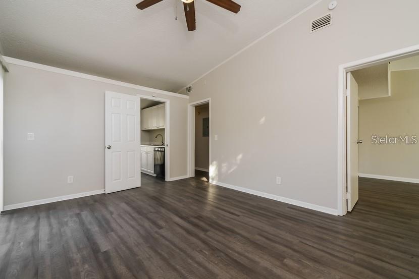 An interior room with gray wood-look flooring, white walls, and two open doorways — 559 MARTIN PLACE BOULEVARD, APOPKA, FL