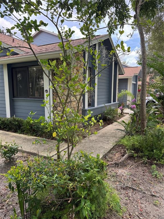The exterior of a house features horizontal siding, stone pillars, and a covered front entryway — 519 STANTON PLACE, LONGWOOD, FL