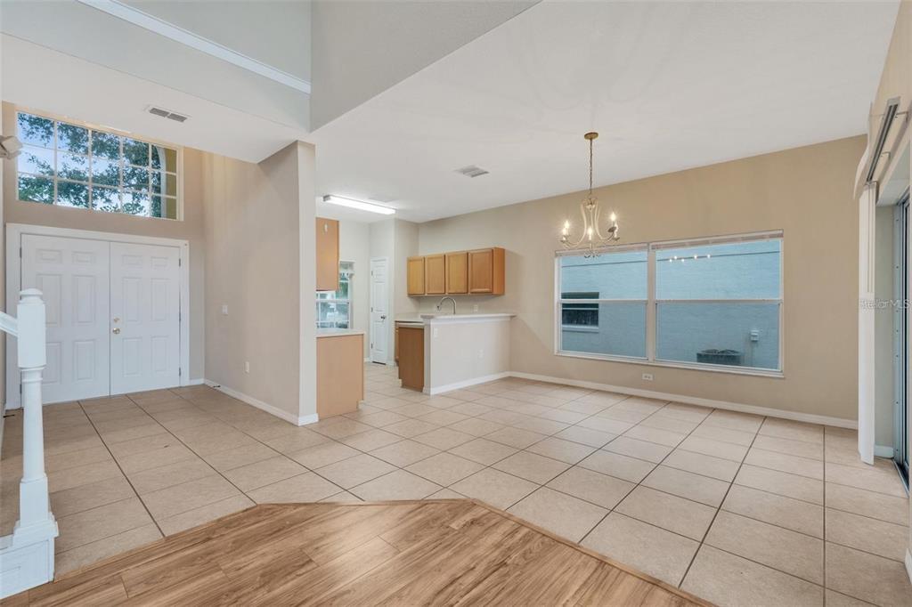 An open-concept dining area with tile flooring, a chandelier, and a view of the kitchen — 318 WINDSOR PLACE, DAVENPORT, FL