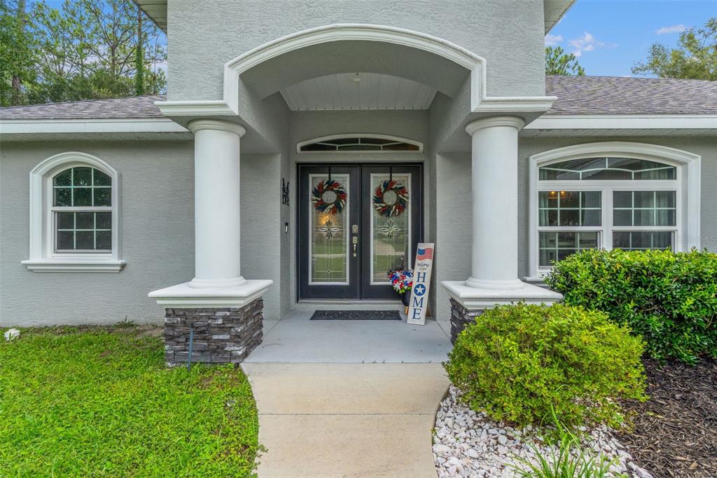 The exterior front entrance features a covered porch with two white columns and double doors — 4631 N RUSHMORE LOOP, BEVERLY HILLS, FL