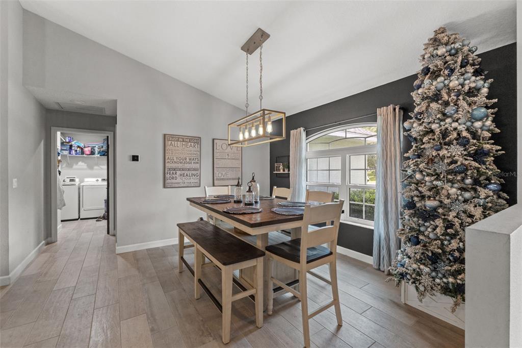 A dining area features a wooden table with bench seating, a chandelier, and a Christmas tree — 4631 N RUSHMORE LOOP, BEVERLY HILLS, FL