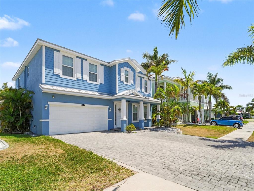 A two-story blue house with white trim and a paved driveway under a clear sky — 6417 KEY ISLAND AVE, APOLLO BEACH, FL