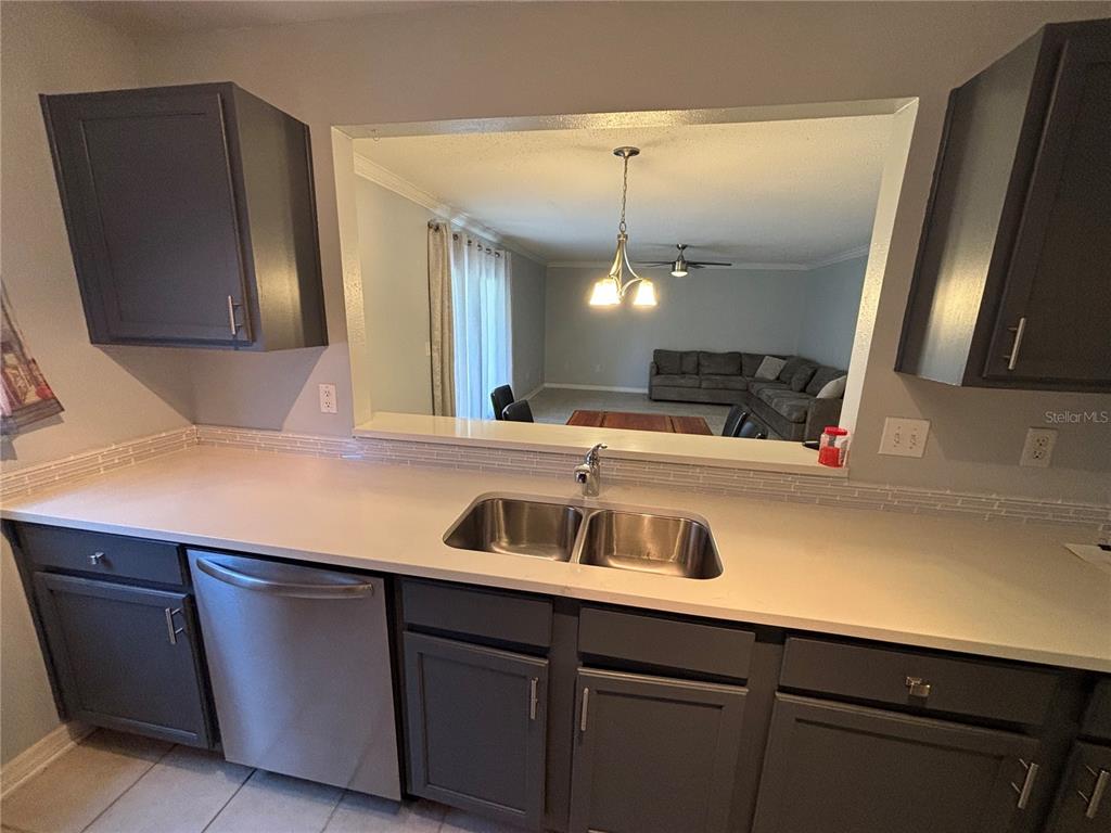 A living and dining area with tile floors, a ceiling fan, and a sectional sofa — 1968 TOUCAN WAY UNIT 1404, SARASOTA, FL