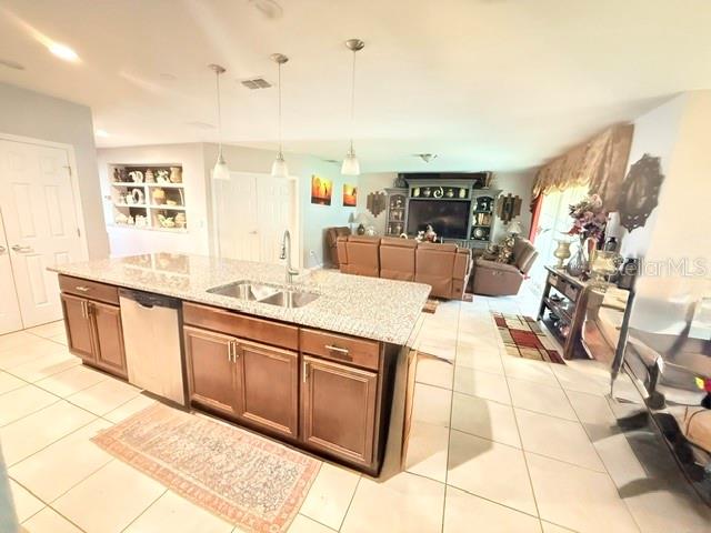 A kitchen with granite countertops and wood cabinets opens into a living room with furniture — 2365 BARTON BAY COURT, KISSIMMEE, FL