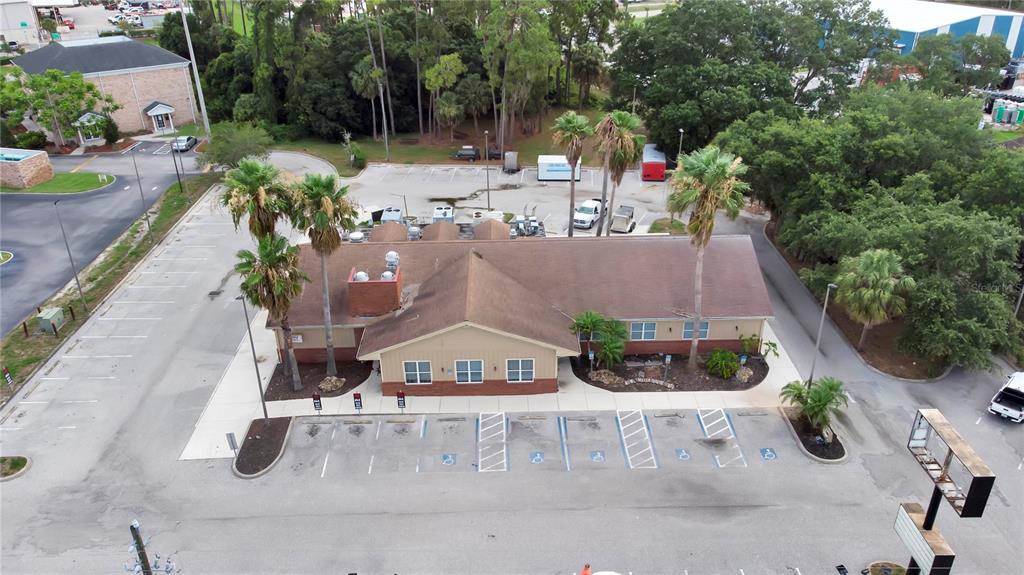 An aerial view shows a commercial building with a brown roof and surrounding parking lot — 1152 TAMIAMI TRAIL, PORT CHARLOTTE, FL