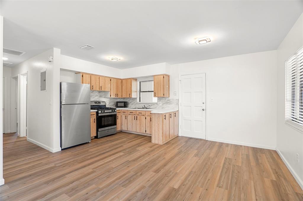 A kitchen with wood cabinets, stainless steel appliances, and wood-look flooring in an open room — 2189 S SMATHERS CIRCLE, MELBOURNE, FL