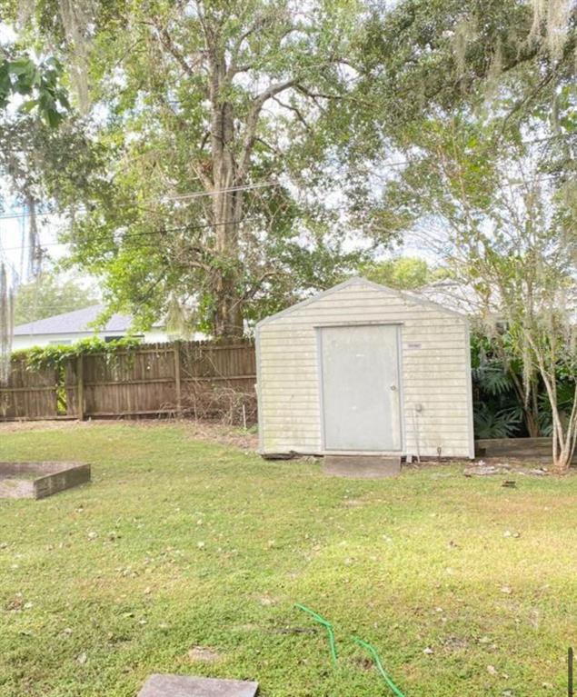 A kitchen features white cabinets, a stainless steel refrigerator, a white stove, and wood-look flooring — 2412 MARSHALL AVENUE, SANFORD, FL