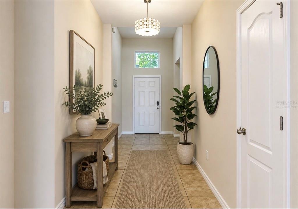 A bright entryway features a console table, a potted plant, and a white front door — 619 WABASH BREEZE CIRCLE, RUSKIN, FL
