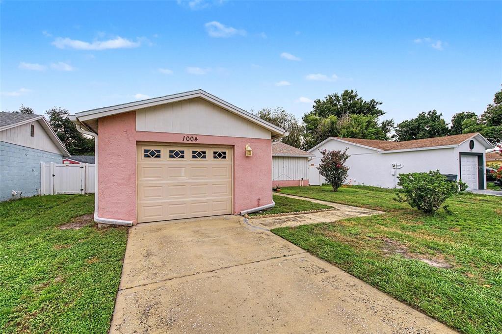 A pink detached garage with a beige door stands on a grassy lot — 1004 COOLWOOD PLACE, BRANDON, FL