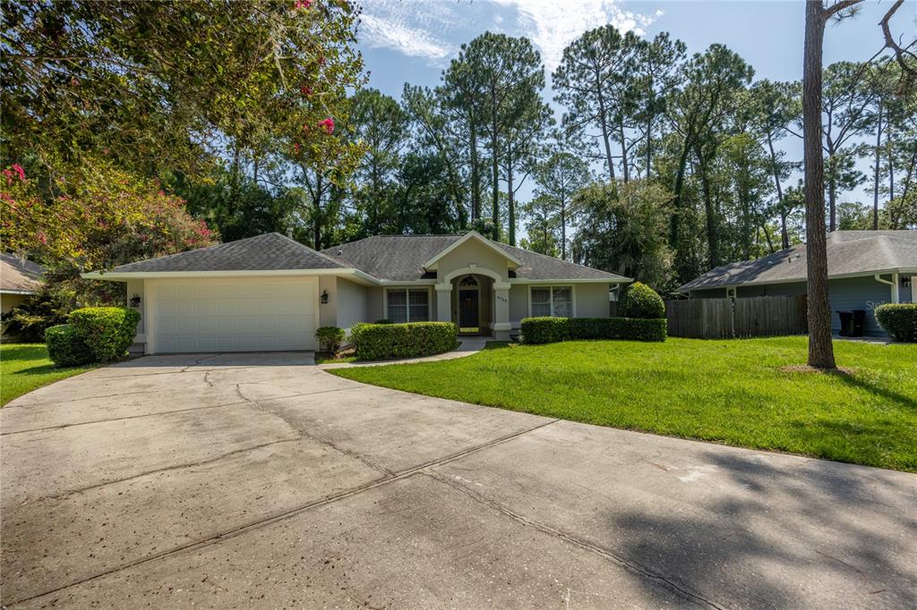 A single-story house with a two-car garage, concrete driveway, and surrounding trees — 6739 NW 34TH TERRACE, GAINESVILLE, FL