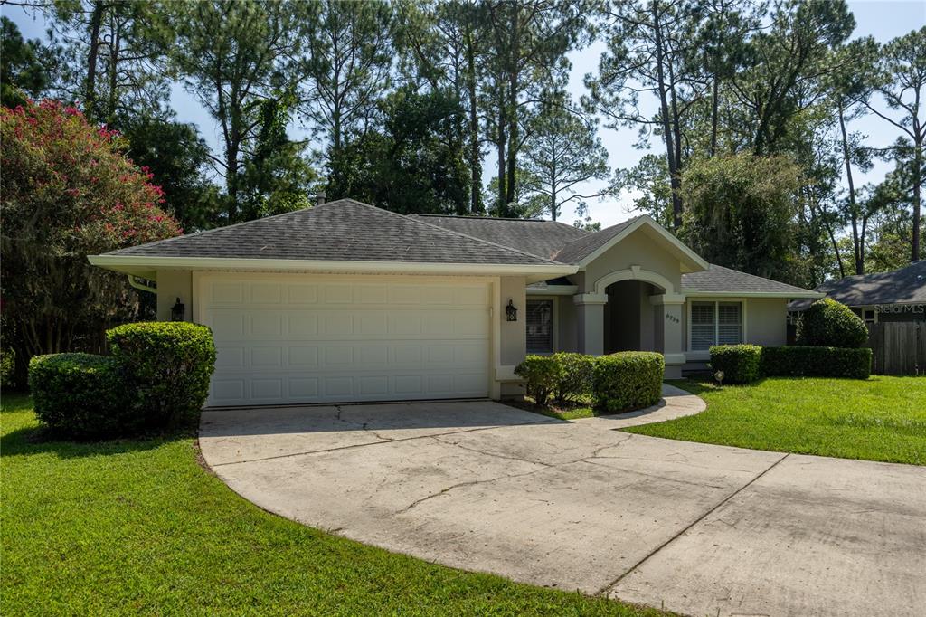 A single-story house with a two-car garage, a concrete driveway, and a landscaped front yard — 6739 NW 34TH TERRACE, GAINESVILLE, FL