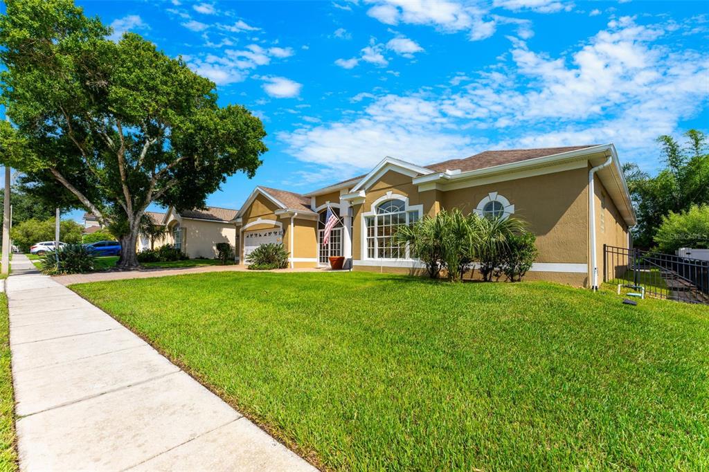 A single-story tan house with a large front lawn, a sidewalk, and a mature tree — 426 PALM CREST LANE, LAKE MARY, FL