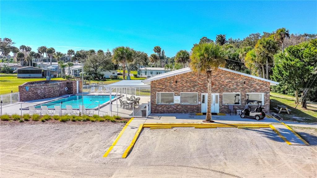 An exterior view of a brick building with a swimming pool and a golf cart — 102 ASH STREET, EDGEWATER, FL