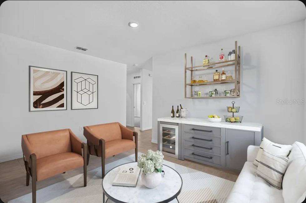 This virtually staged living area features a home bar, two leather armchairs, and a sofa — 9316 CHISWELL TRAIL, PALMETTO, FL