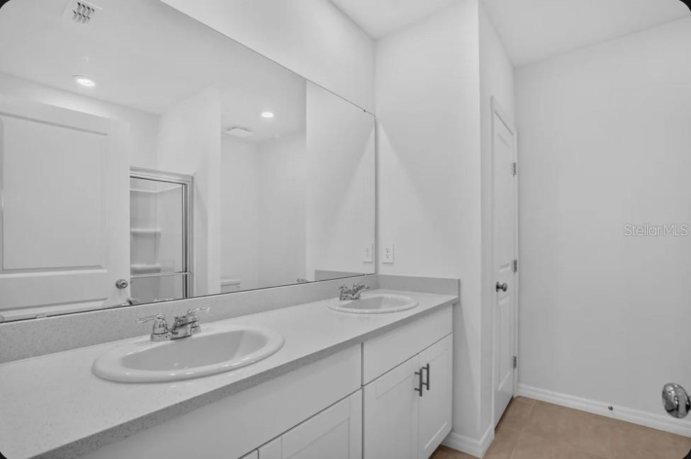 A virtually staged bedroom features a white bed, two nightstands, and a window overlooking water — 9316 CHISWELL TRAIL, PALMETTO, FL