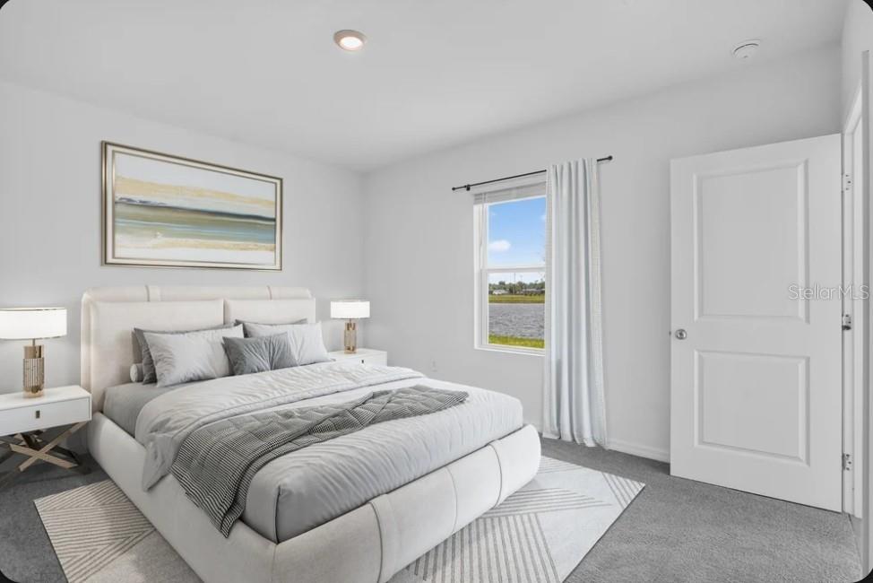 A bathroom with a double vanity, white cabinets, light countertops, and a large wall mirror — 9316 CHISWELL TRAIL, PALMETTO, FL