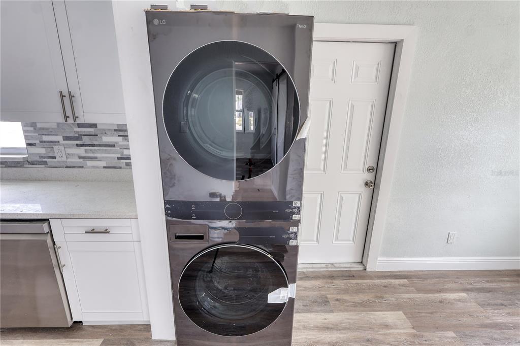 A stacked LG washer and dryer unit stands in a kitchen with white cabinets — 116 44TH STREET S, ST PETERSBURG, FL