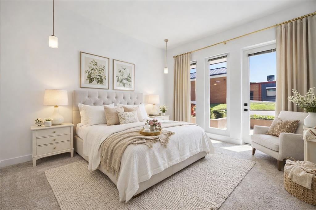 A bright bedroom features a tufted headboard, neutral bedding, and a glass door leading outside — 100 N DEWEY STREET UNIT 401, EUSTIS, FL
