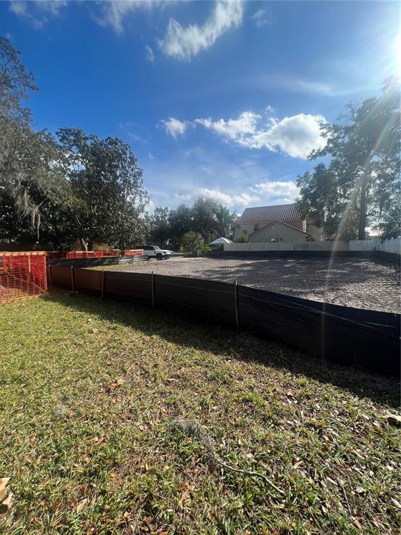 A vacant residential lot is enclosed by black silt fencing under a sunny sky — 731 MIDGET DRIVE, WINTER PARK, FL