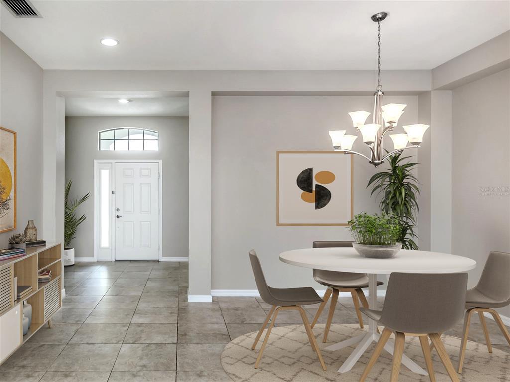 A dining area with a round table and chairs sits near a tiled entryway — 11406 BELVEDERE TERRACE, BRADENTON, FL