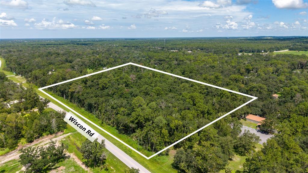 An aerial view shows a rectangular plot of wooded land bordering a paved road — 10.30 Acres WISCON ROAD, BROOKSVILLE, FL