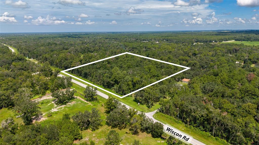 An aerial view shows a wooded plot of land outlined in white next to a road — 10.30 Acres WISCON ROAD, BROOKSVILLE, FL