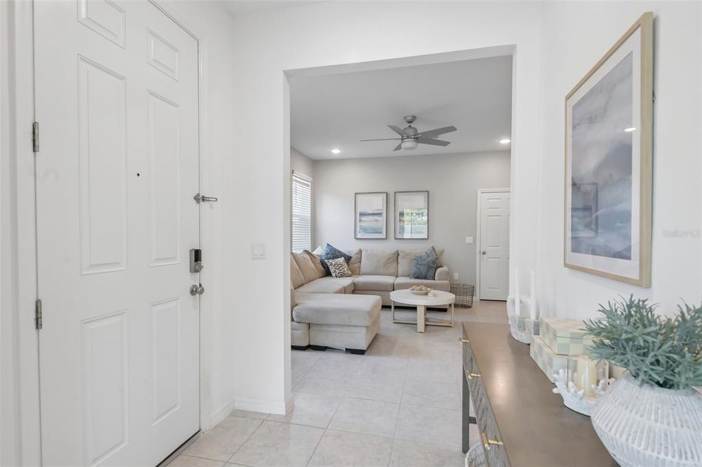 A view from an entryway looking into a living room with a sectional sofa — 34162 ROGALLO LANE, WESLEY CHAPEL, FL