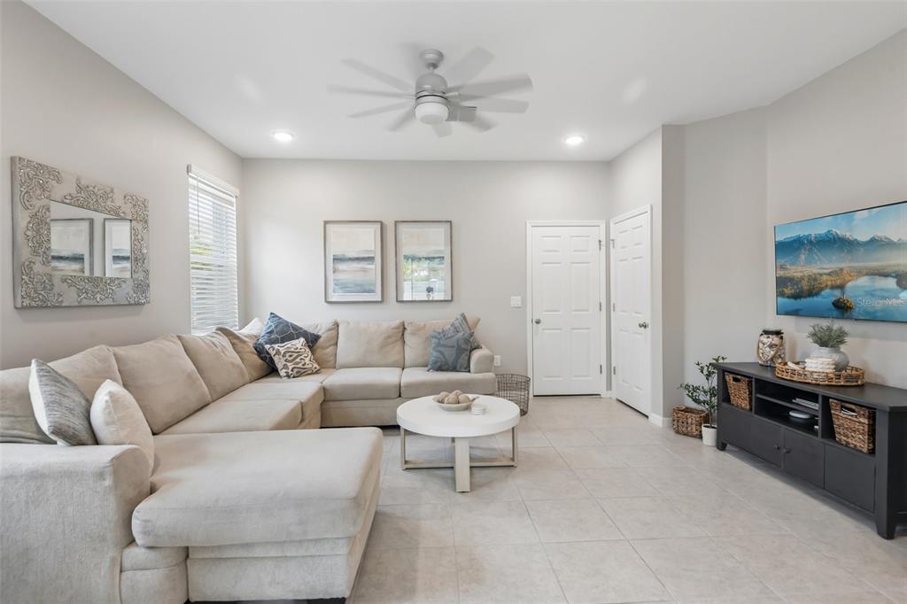 A living room features a beige sectional sofa, a white coffee table, and a wall-mounted television — 34162 ROGALLO LANE, WESLEY CHAPEL, FL
