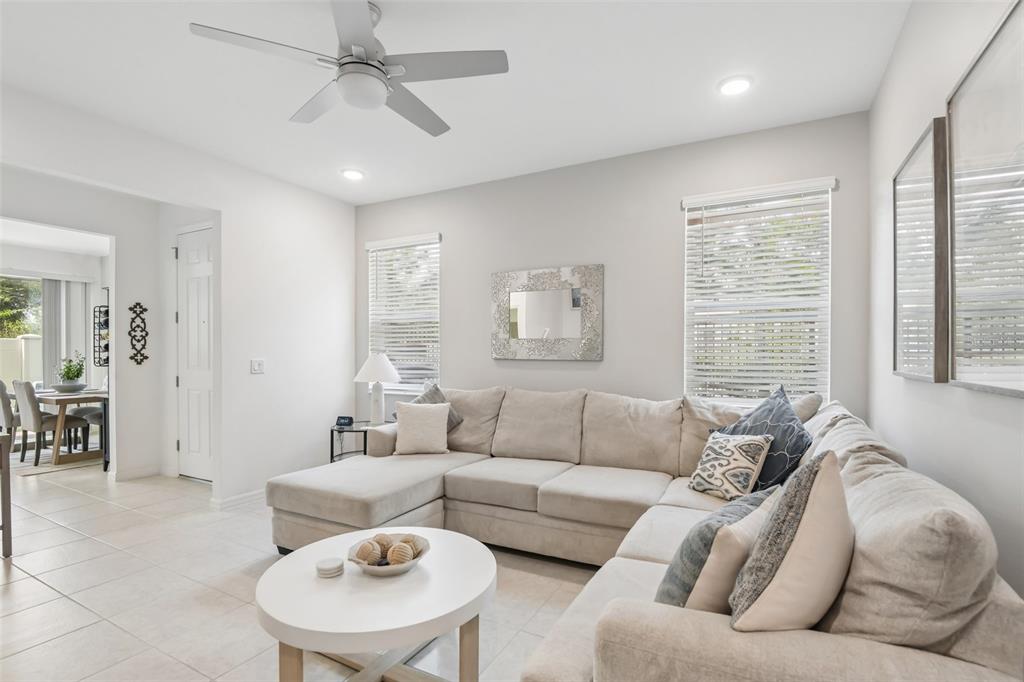 A living room features a beige sectional sofa, a white coffee table, and tile flooring — 34162 ROGALLO LANE, WESLEY CHAPEL, FL