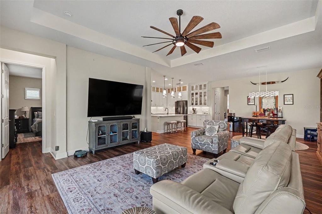 A white kitchen features a center island, stainless steel appliances, and wood-look flooring — 4502 RENWICK DRIVE, PARRISH, FL