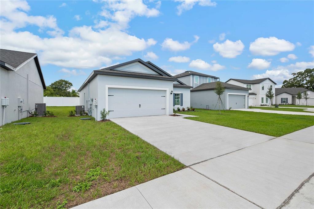 A light blue single-story house with a two-car garage and a concrete driveway — 13284 TULA LOOP, ASTATULA, FL