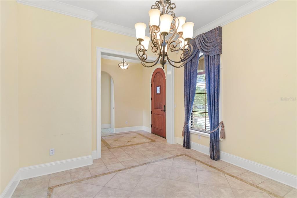 An entryway features tile flooring, a decorative chandelier, and a wooden front door — 1421 CHAPMAN CIRCLE, WINTER PARK, FL