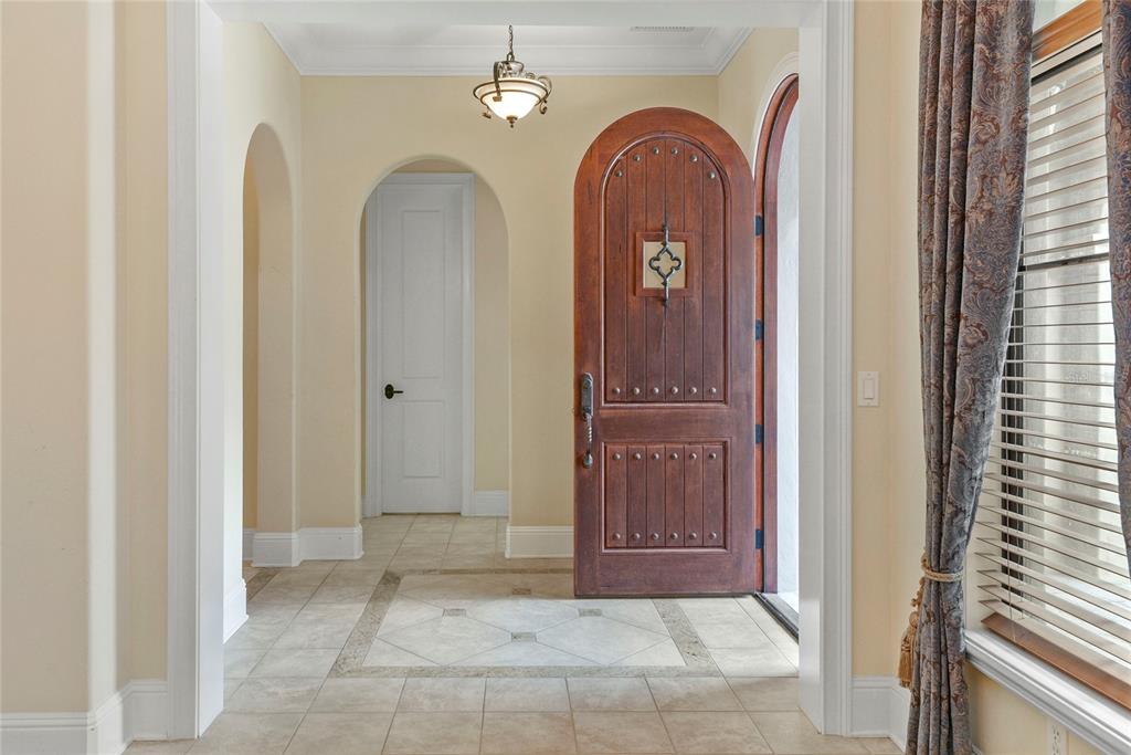 An entryway features a tiled floor, an arched wooden front door, and an arched doorway — 1421 CHAPMAN CIRCLE, WINTER PARK, FL