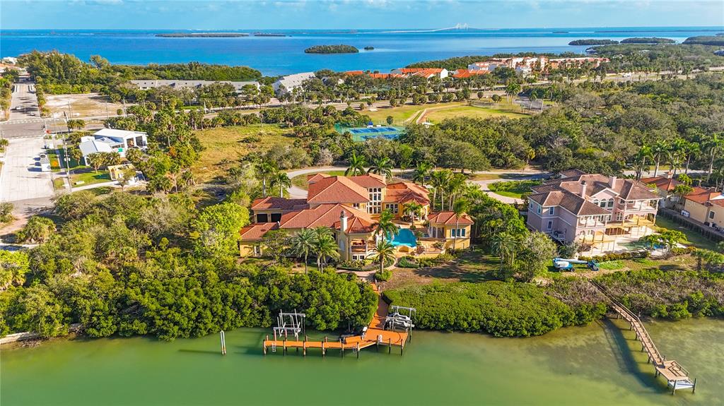An aerial view of a large waterfront house with a pool, dock, and surrounding vegetation — 1363 OCEANVIEW DRIVE, TIERRA VERDE, FL