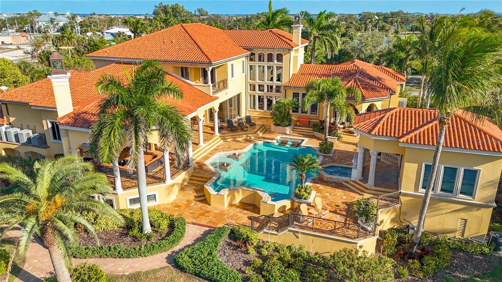 An aerial view of a yellow Mediterranean-style house with a tile roof and swimming pool — 1363 OCEANVIEW DRIVE, TIERRA VERDE, FL