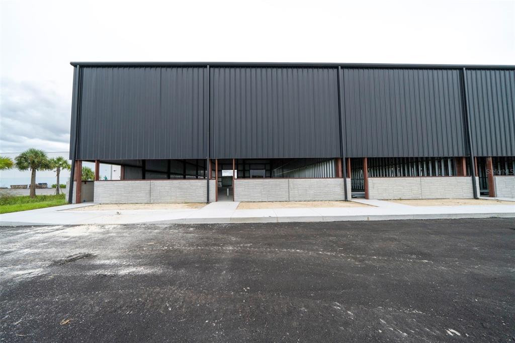 An exterior view of two modern, black industrial warehouse buildings under a blue sky — 8411-8419 DUFFIE DRIVE, PUNTA GORDA, FL
