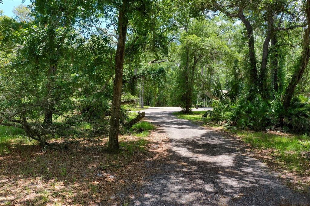 A single-story house with tan siding and a covered front porch sits on a grassy lot — 3296 N OLD DIXIE HIGHWAY, BUNNELL, FL