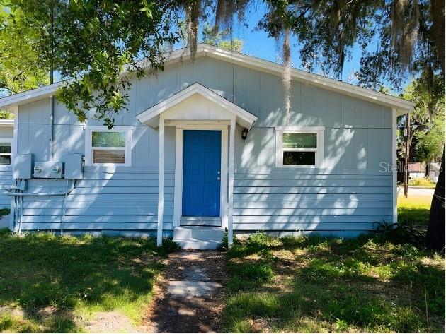 A light blue house with a bright blue front door and a small covered entryway — 918 E 10TH STREET Unit B, SANFORD, FL