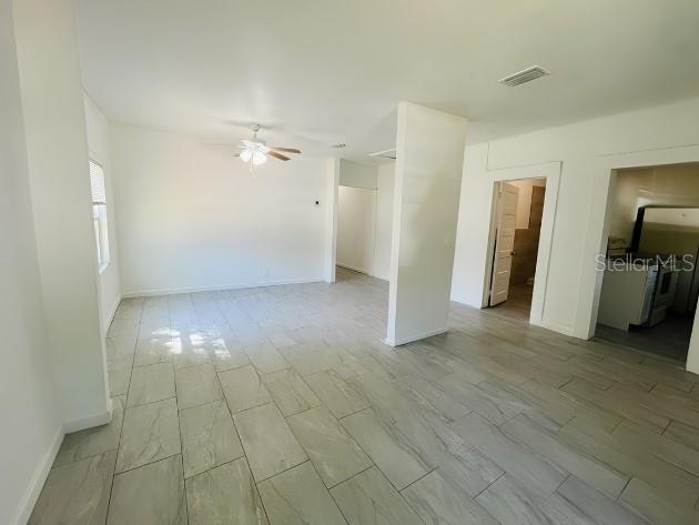 An empty room with light-colored tile flooring, white walls, and a ceiling fan — 918 E 10TH STREET Unit B, SANFORD, FL