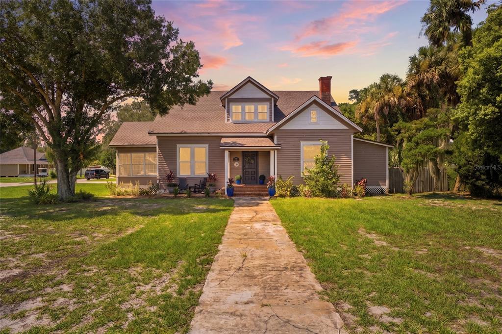 A two-story house with brown siding, a brick chimney, and a concrete walkway — 524 E MAGNOLIA STREET, ARCADIA, FL