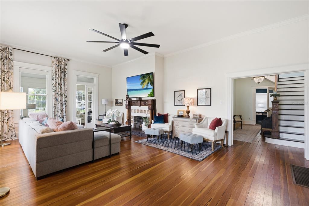 A living room with hardwood floors, a fireplace, a ceiling fan, and a staircase — 524 E MAGNOLIA STREET, ARCADIA, FL