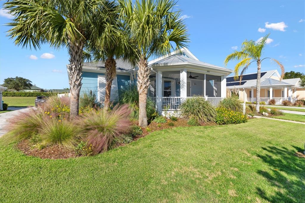 A blue house with a screened-in porch and palm trees in the front yard — 1052 SUGAR LOAF KEY LOOP, LADY LAKE, FL