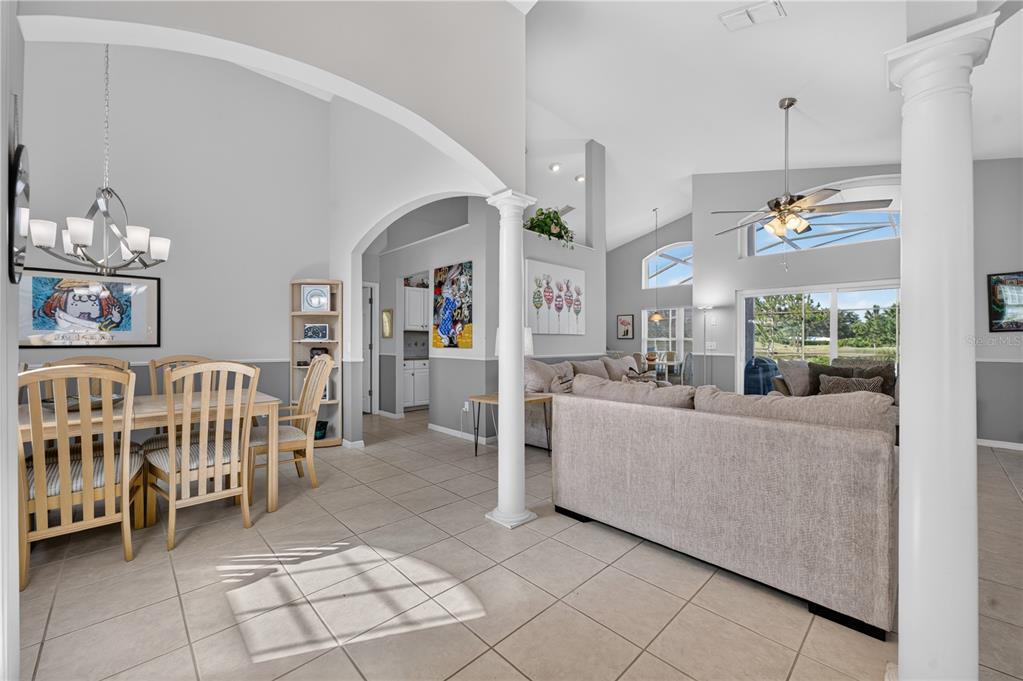 A living room features light gray walls, white columns, tile flooring, and a large sectional sofa — 213 SPANISH MOSS ROAD, DAVENPORT, FL