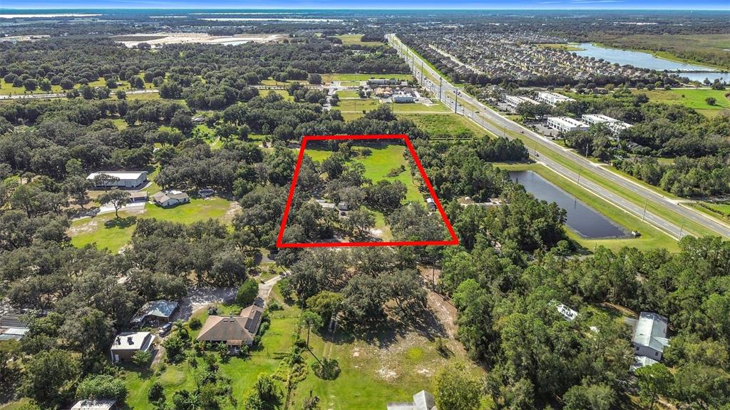 An aerial view shows a rectangular plot of land outlined in red near a highway — 4980 DISSTON DRIVE, ST CLOUD, FL