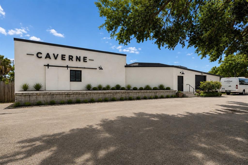 The exterior of a white commercial building features a loading dock and a parked van — 4214 W VIRGINIA AVE UNIT 12, TAMPA, FL