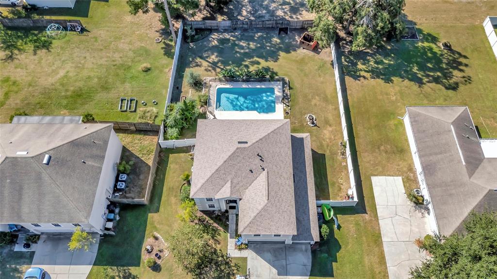 A backyard features a rectangular swimming pool with a concrete deck and a two-story house — 4540 SE 30TH STREET, OCALA, FL