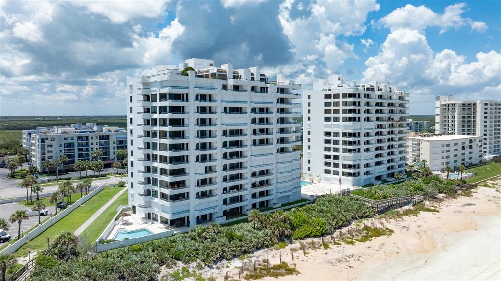 An aerial view of two white high-rise condominium buildings situated next to a sandy beach — 5275 S ATLANTIC AVENUE UNIT 1007, NEW SMYRNA BEACH, FL